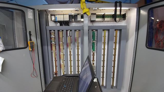 A PLC panel with I/O data connections being routed.